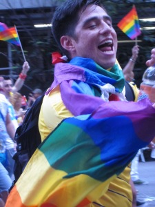 Jubilant marcher all wrapped up in the rainbow flag.